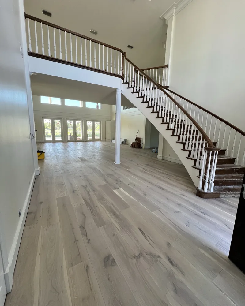 New wide-plank wood floors installed through a two-story foyer in Prestancia, Sarasota