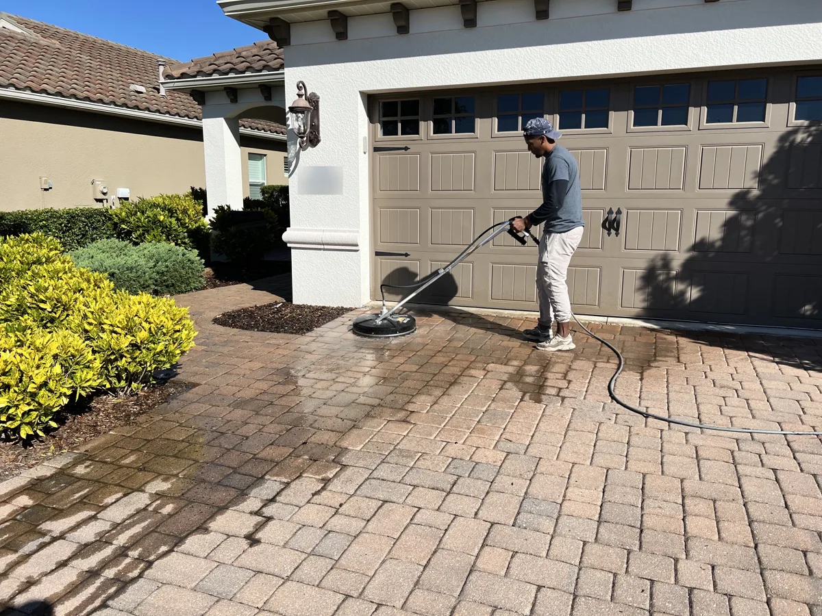 Crew cleaning a paver driveway with a surface cleaner