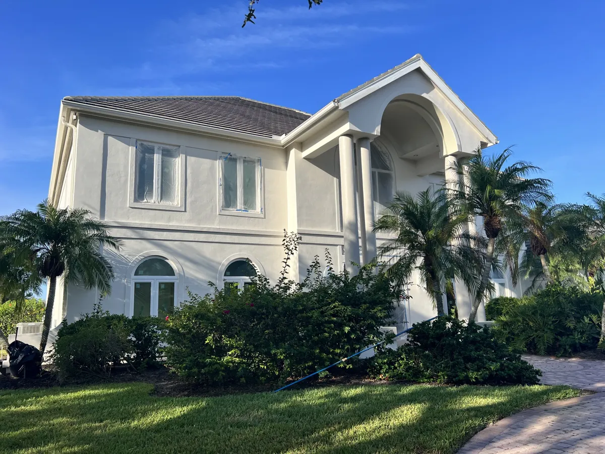 Two-story stucco home with columns and palm trees freshly painted in Prestancia, Sarasota