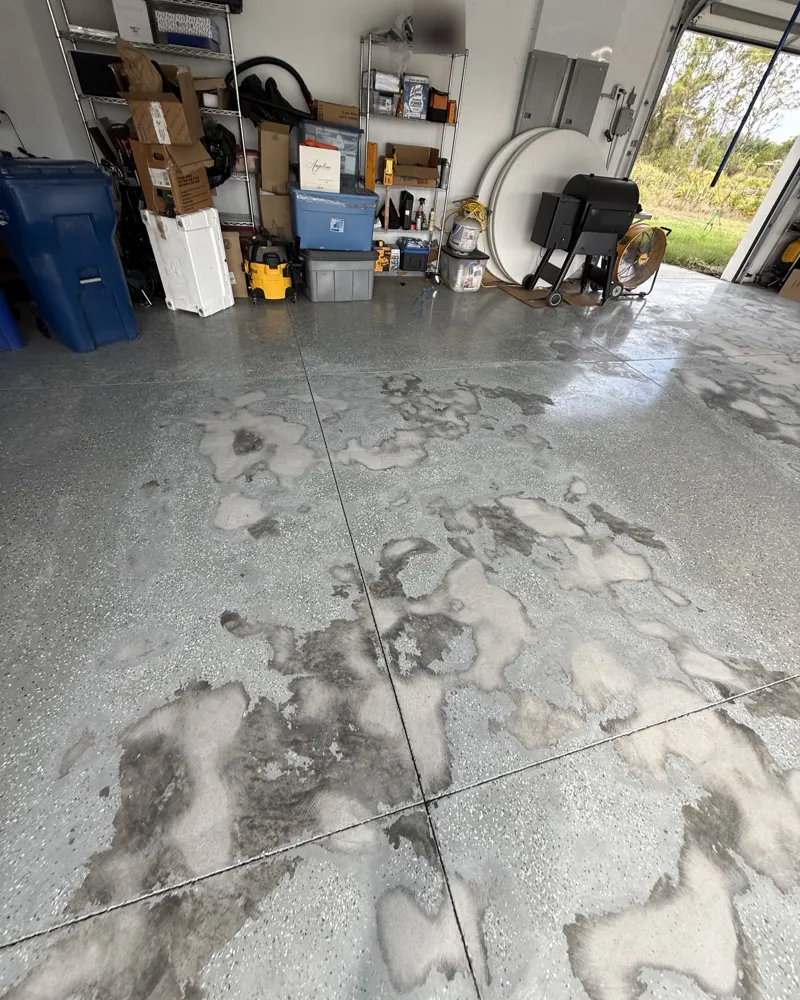 Before: garage floor with the old flake coating peeling and worn away across the slab