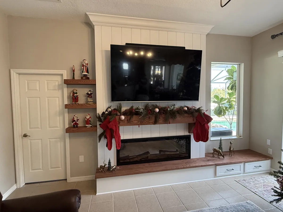 After: new floor-to-ceiling shiplap fireplace and TV wall with electric fireplace, wood mantel, wood hearth bench with drawers and floating shelves