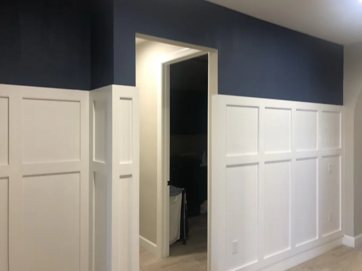 After: the wainscoting painted white under a navy blue upper wall