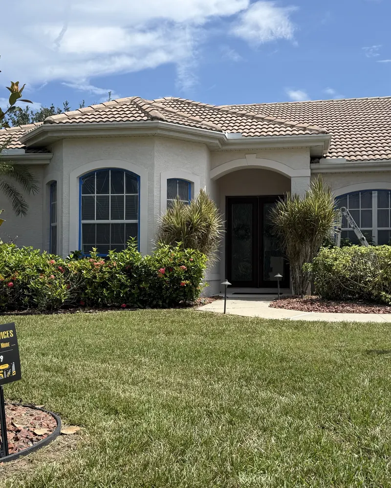 During: stucco home with windows masked for exterior painting