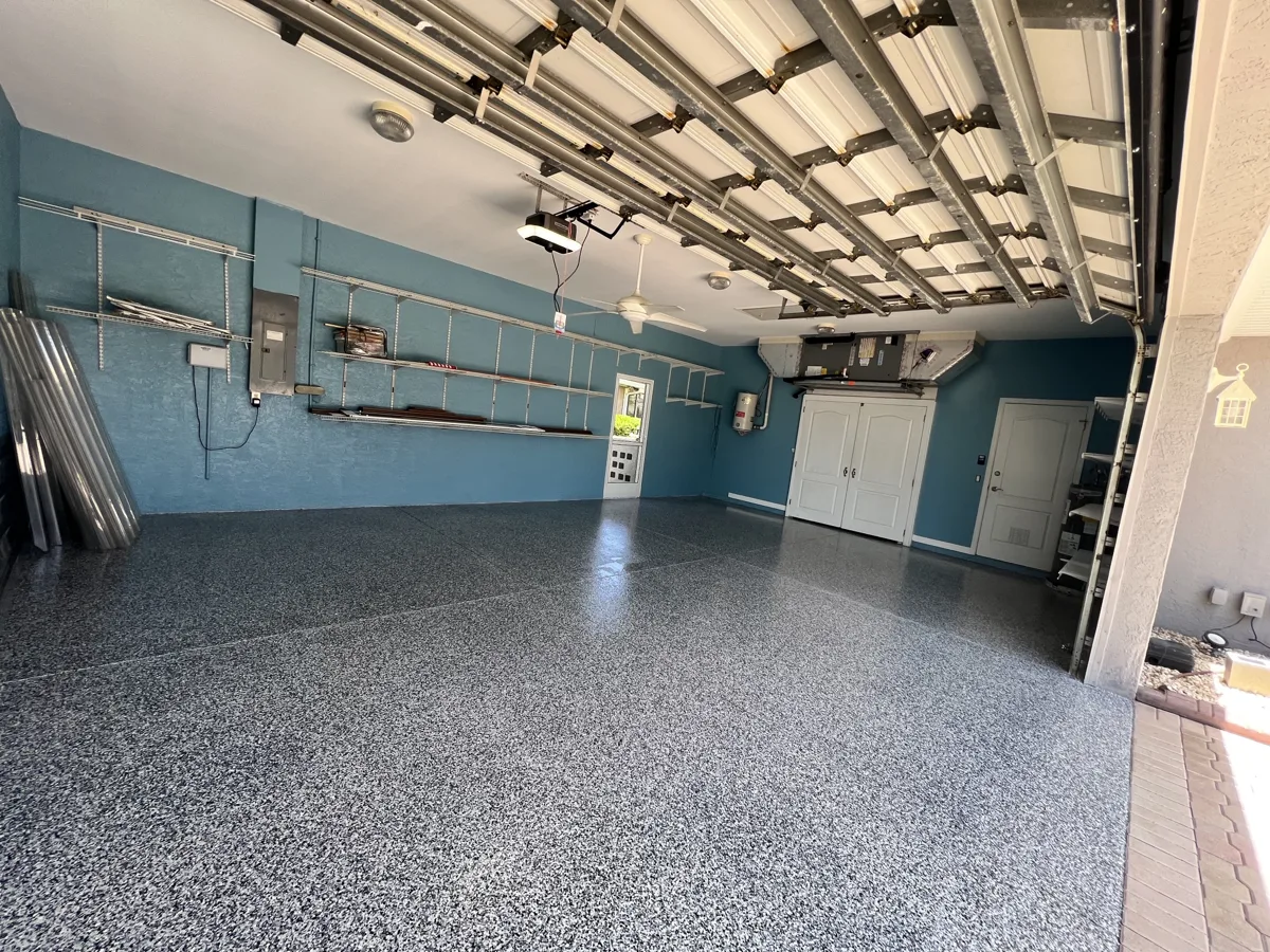 After: the same garage with a full-broadcast blue-gray flake floor coating and glossy finish