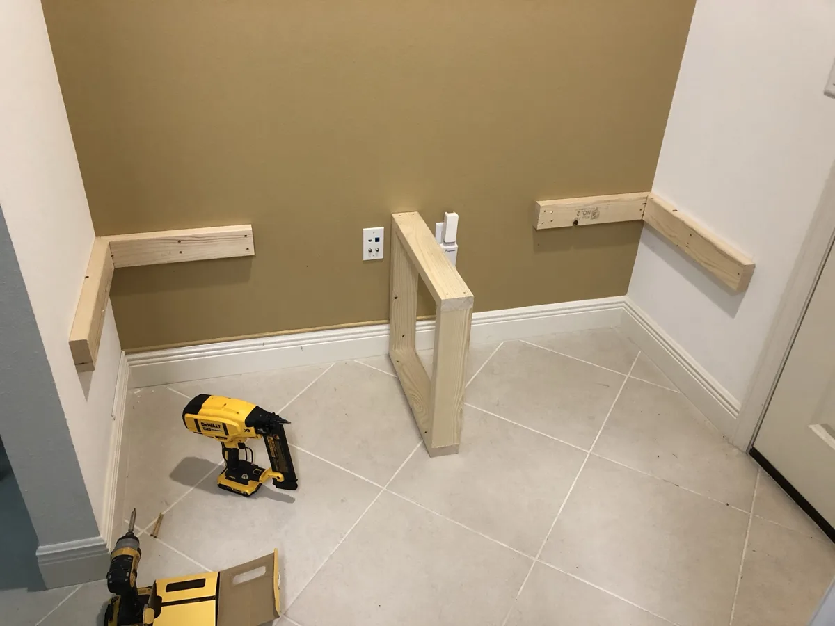 Framing: wood ledgers and a center support frame for a built-in bench in a wall nook