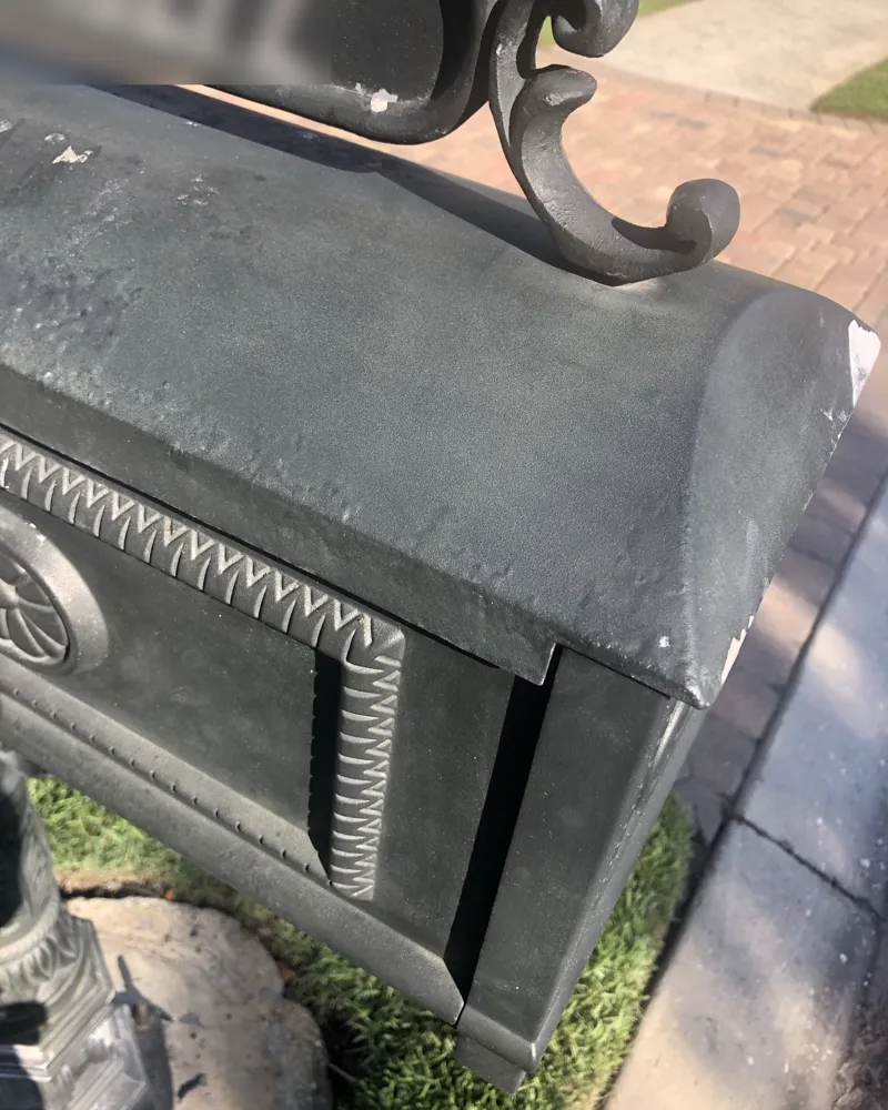Before: cast aluminum mailbox with faded, chalky finish and chipped paint on the edges