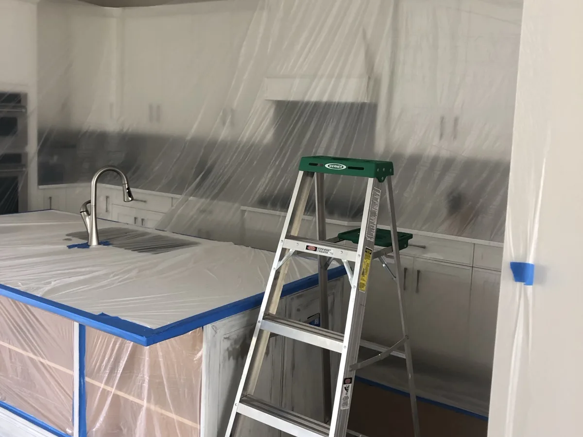 Masked: the whole kitchen wrapped in plastic with the island primed for spraying