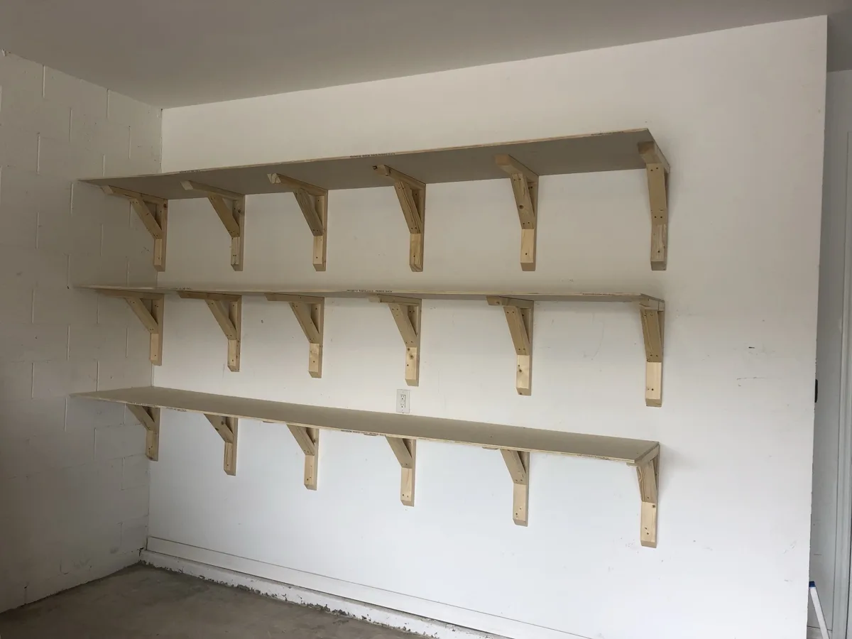 Built: three long shelves on custom wood brackets anchored to the wall