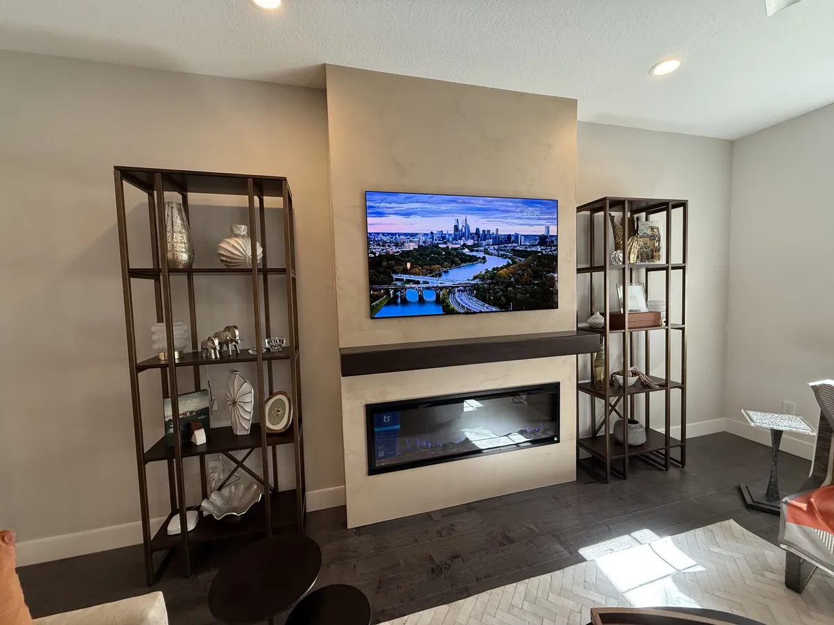 After: the same wall with a smooth microcement feature wall, mounted TV, wood mantel and linear fireplace