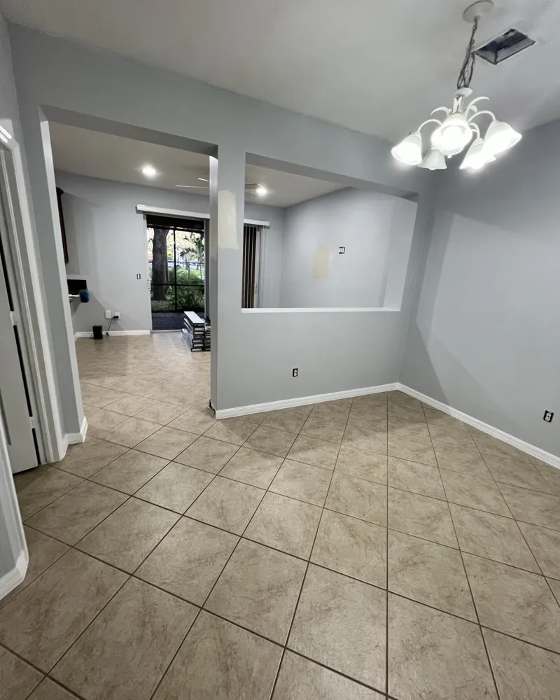 Before: dining area with dated diagonal tile, light blue walls and a half wall with a pass-through opening