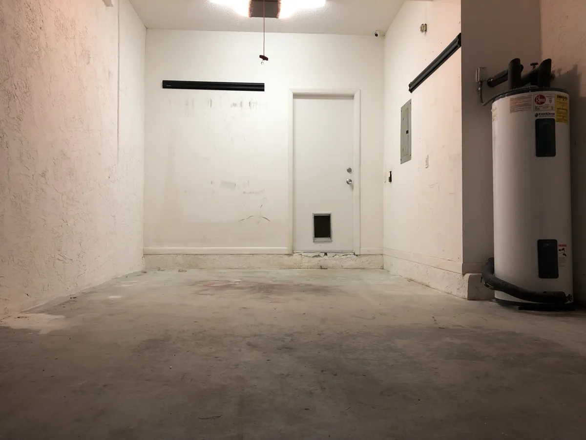 Before: one-car garage with scuffed walls and bare, stained concrete