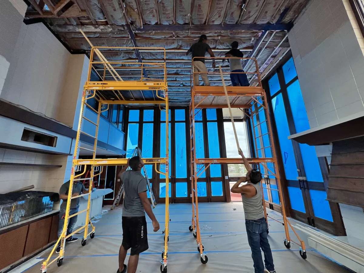 During: crew on two rolling scaffolds installing furring strips on the tall ceiling, floors and windows protected