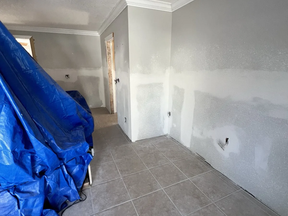 After: new drywall installed on the lower walls, taped, finished and textured to match, ready for paint