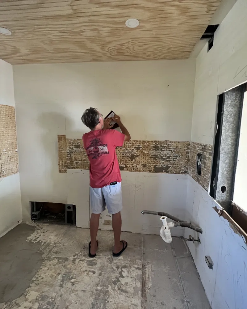 Before: kitchen gutted to bare walls and subfloor, old backsplash removed, layout being marked