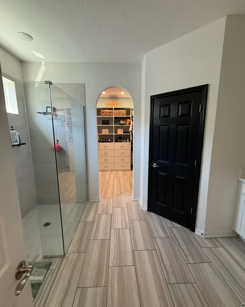 After: arched opening from the primary bathroom into the walk-in closet