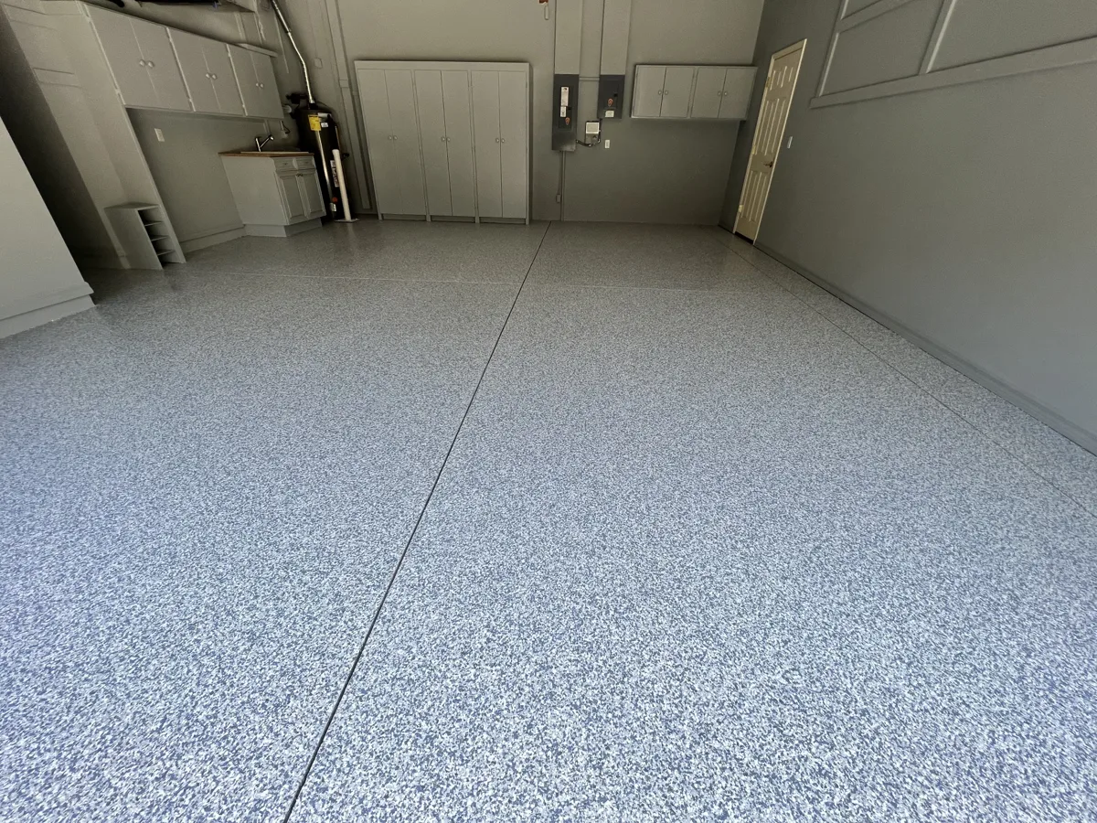 After: finished garage with full-flake gray and blue floor coating, gray walls and light gray painted cabinets