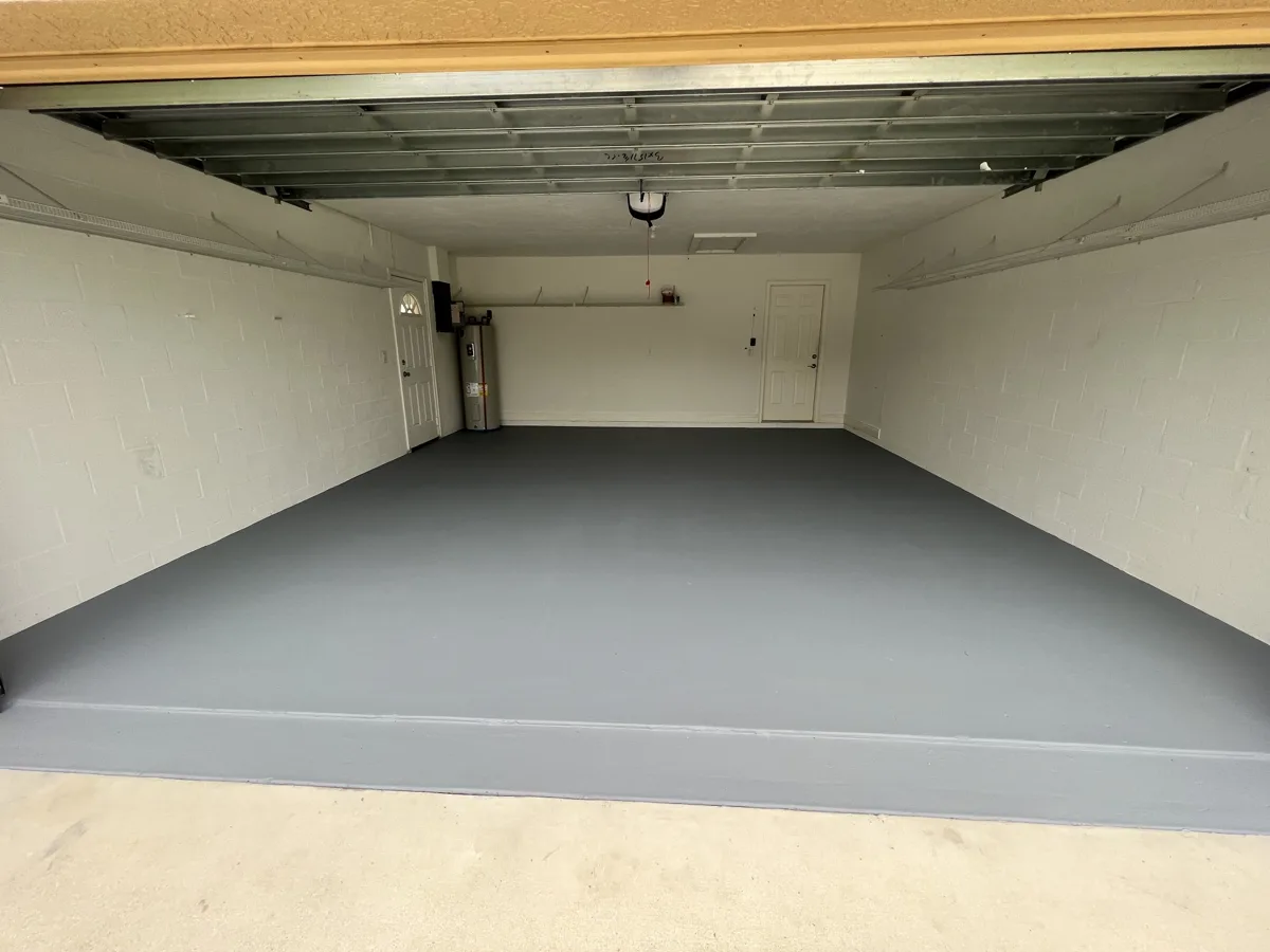 After: two-car garage floor and front step recoated in a clean, solid gray finish