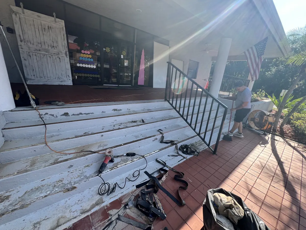 Before: school entrance steps with peeling paint and worn non-slip strips being removed