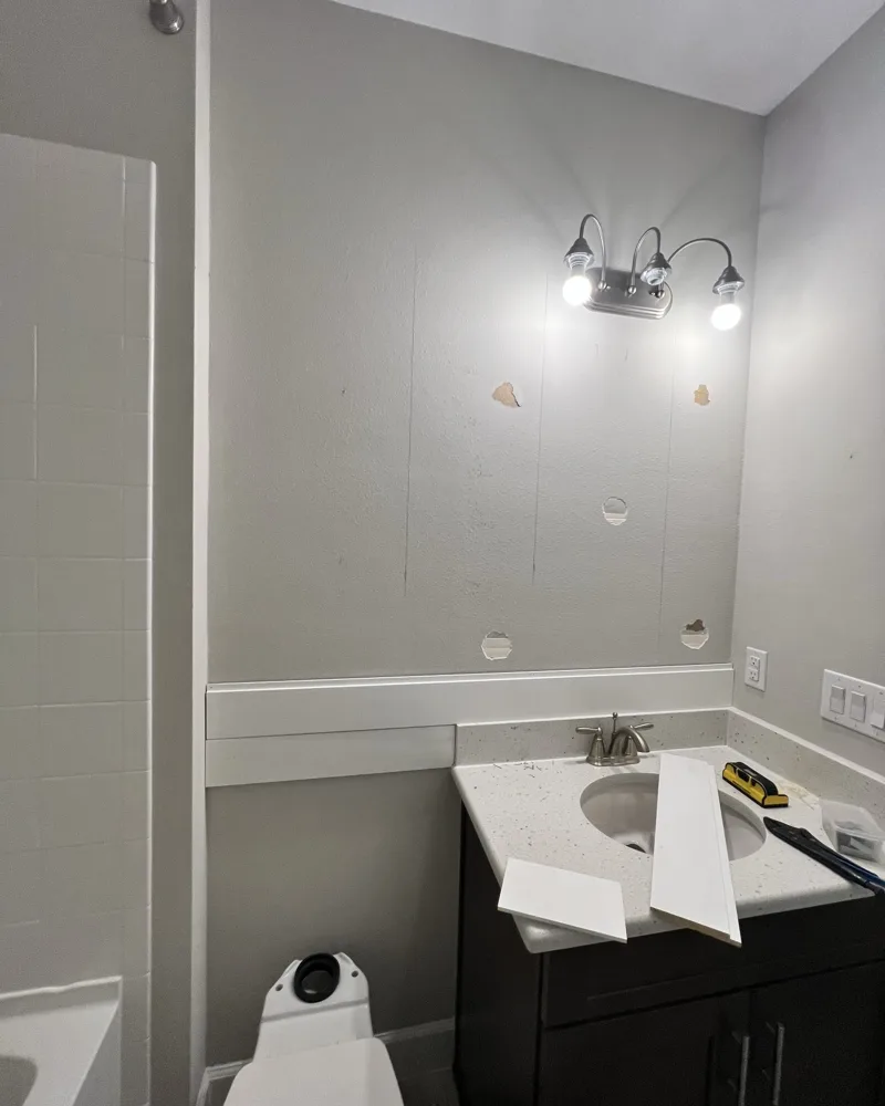 Before: bathroom vanity wall with anchor holes and the first shiplap boards going up