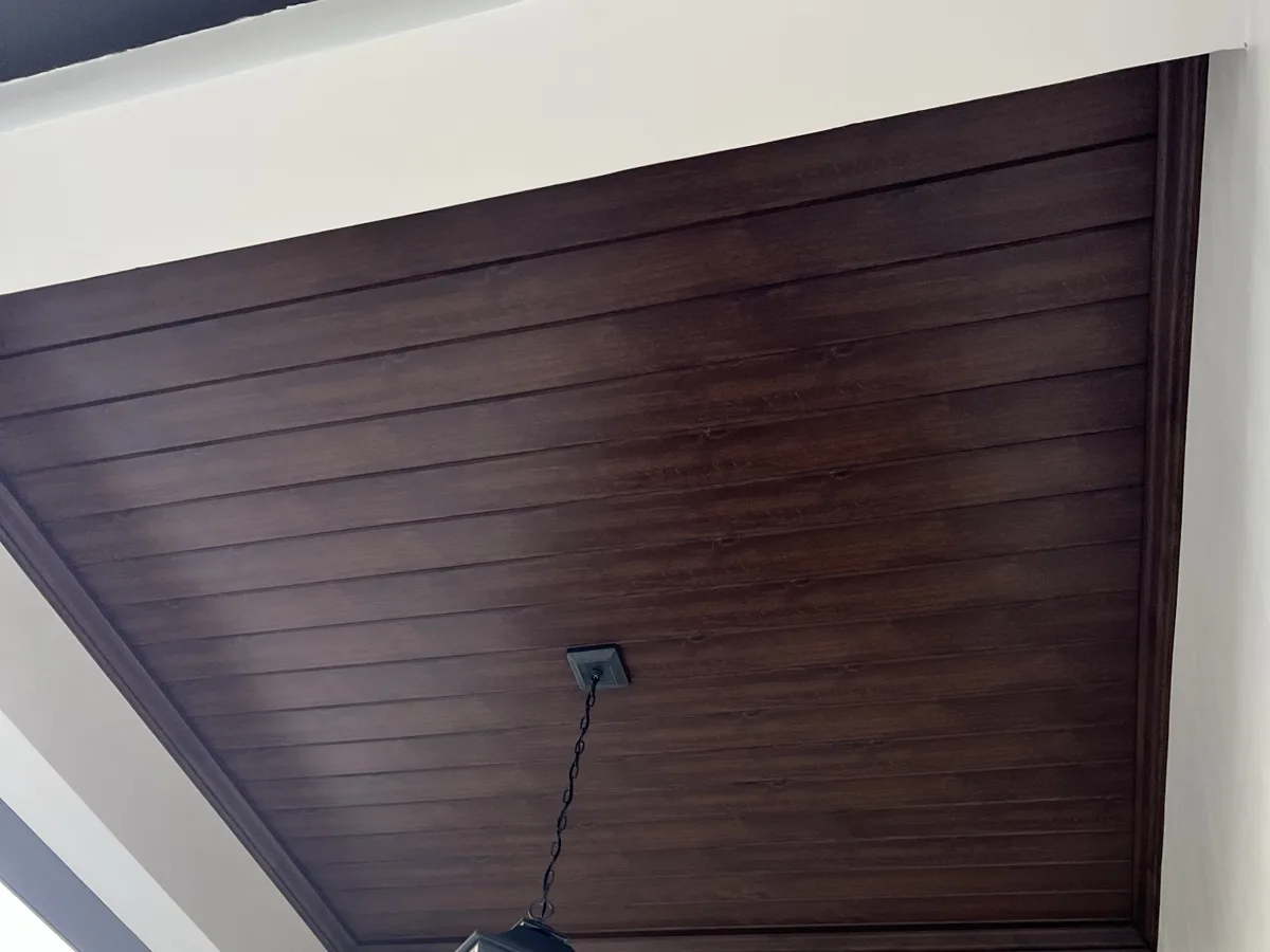 After: close-up of the wood-grain VersaTex PVC ceiling with matching perimeter trim