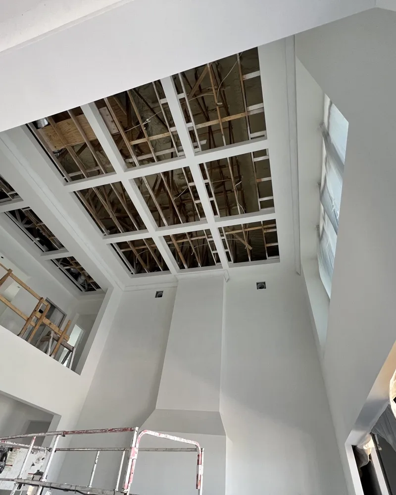 Before: two-story coffered ceiling with open bays showing the framing above