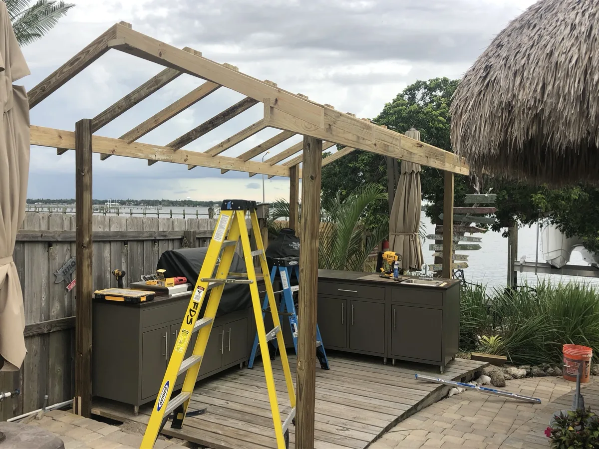 Process: posts, beams and gable rafters framed over the outdoor kitchen cabinets