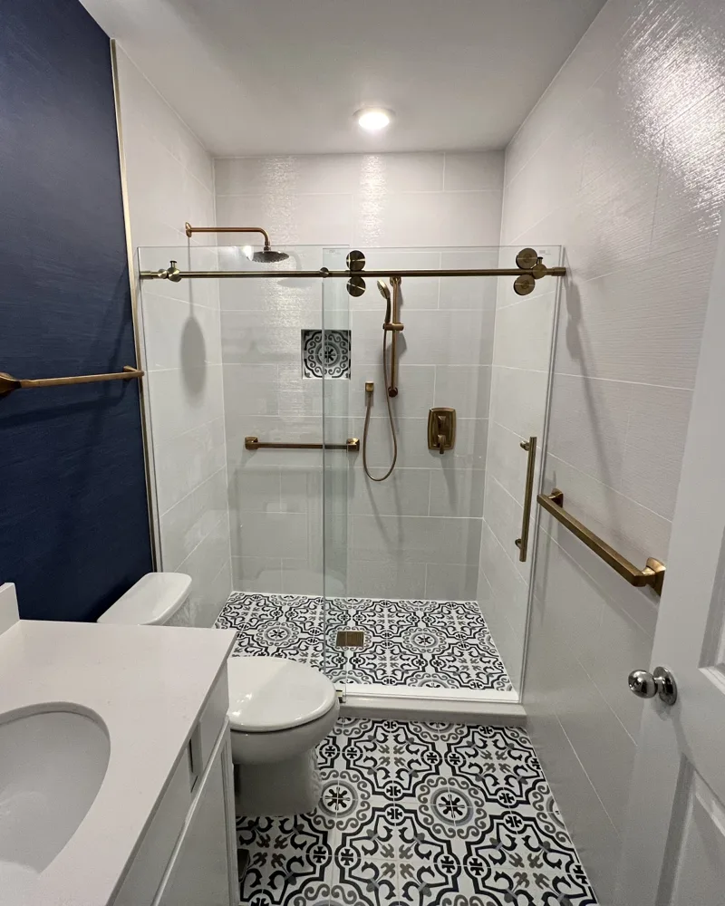 Bathroom remodel with walk-in tiled shower, patterned floor tile and navy accent wall in Parrish