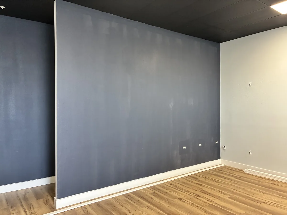 Before: plain painted navy feature wall with new baseboard
